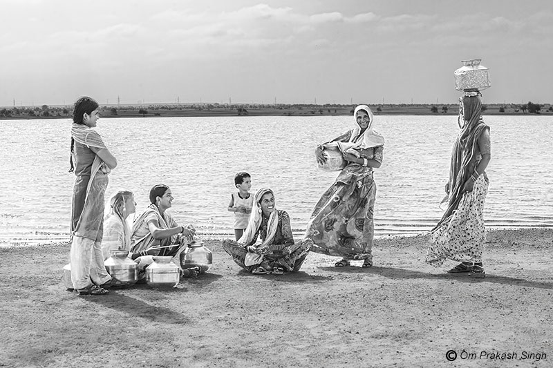 Women and girls from Netsi village sit together on the shores of Viprasar wetland in Jaisalmer, Rajasthan, enjoying the cool breeze while discussing community issues.